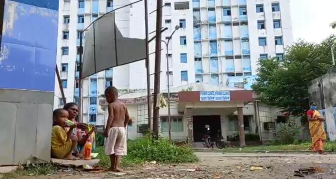 The mother is spending the day with her two children under the open sky at Thane Raiganj Medical College and Hospital
